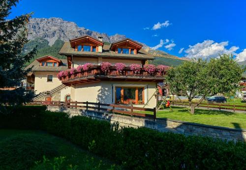 Una casa con flores en el balcón. en Casa Caste, en Bormio