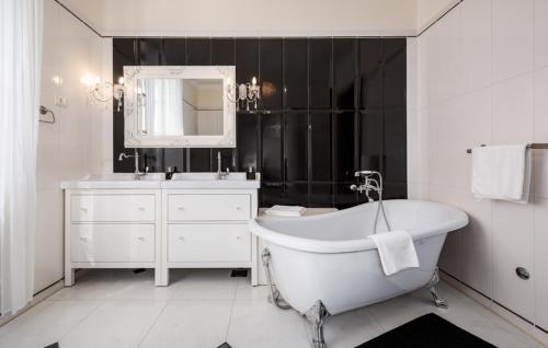 a bathroom with a tub and a sink and a mirror at Villa Vigneri in Novigrad Istria