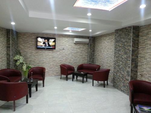 a waiting room with chairs and a tv on a wall at Anya Suit Otel in Denizli