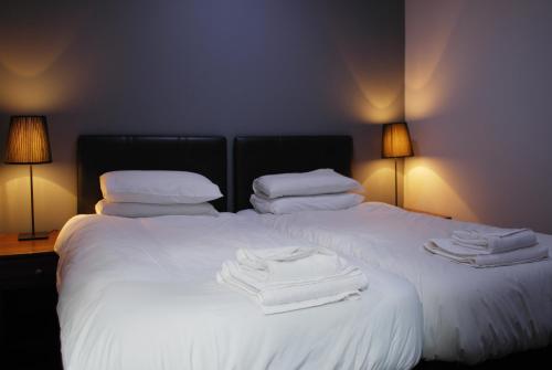 a bedroom with two beds with white towels on them at The Liverpool Inn Hotel in Liverpool