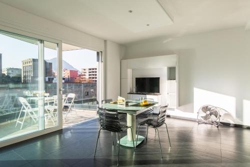 a living room with a table and chairs on a balcony at Roggia Apartments by Quokka 360 - central flats with parking space in Lugano