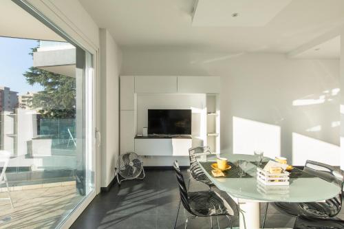 a dining room with a glass table and chairs at Roggia Apartments by Quokka 360 - central flats with parking space in Lugano