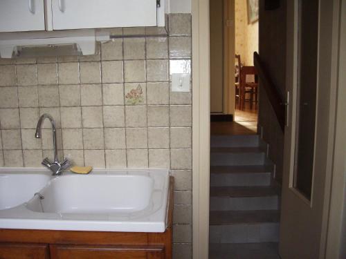 a kitchen with a sink and a hallway with a staircase at Gîte de l'Aubrée 17 in Puy-du-Lac