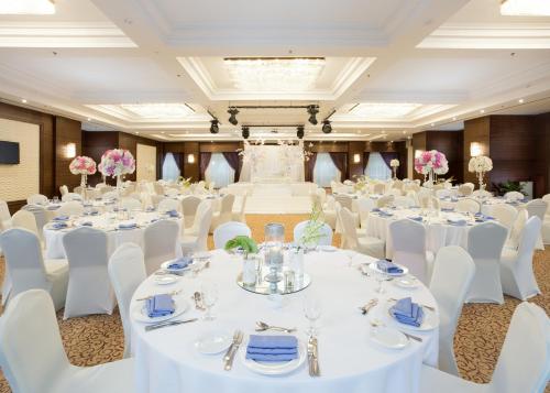 a banquet hall with white tables and chairs and pink flowers at Tolip Golden Plaza in Cairo