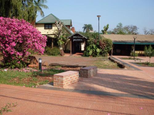 a park with pink flowers and a building at Hosteria Helvecia in Montecarlo