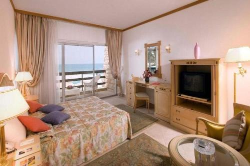 una camera d'albergo con letto e televisore di Retac El Arish a El Arish