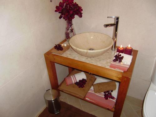 a bathroom with a bowl sink on a table next to a toilet at Romantic Studio in Funchal