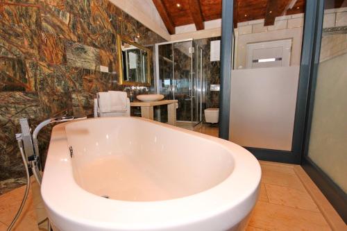a large white tub in a bathroom with a table at Villa Sofia Zavalatica in Čara