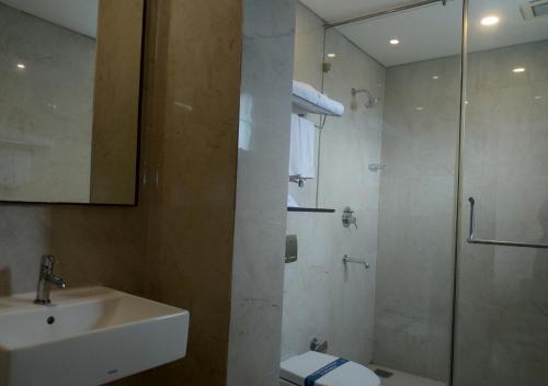 a bathroom with a shower and a sink and a toilet at Grand Arcadia in Tiruchchirāppalli