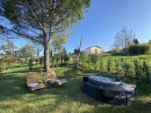 a hot tub and two chairs in a yard at Glamping Tenuta San Pierino Agriturismo in Rosignano Marittimo