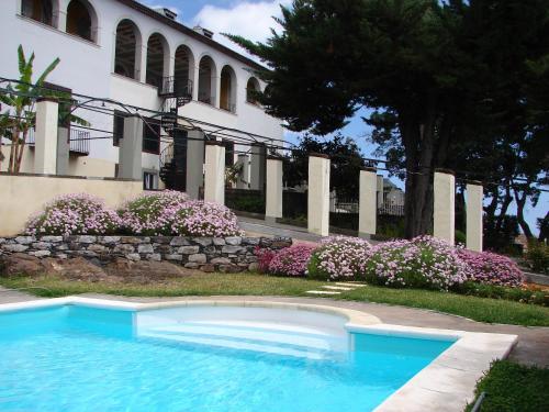 a swimming pool in front of a building with flowers at Romantic Studio in Funchal