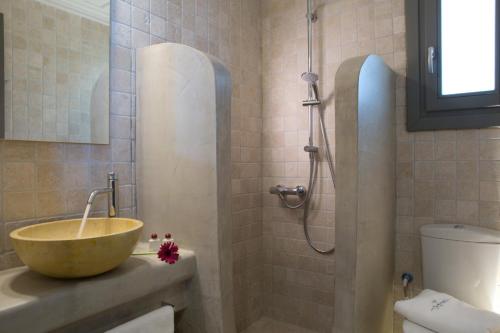 a bathroom with a bowl sink and a shower at Acquaterra Villas in Tsoukaladhes