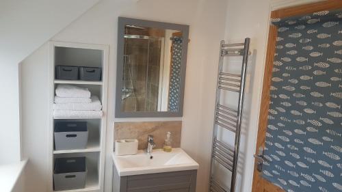 a bathroom with a sink and a mirror at Beautiful 3-bed stone barn in idyllic Hawkshead in Hawkshead