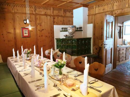 a dining room with a long table with flowers and candles at Gasthof Hotel Doktorwirt in Salzburg