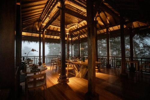 a large wooden building with tables and chairs in it at Tira Vilagna Suites & Spa in Kintamani