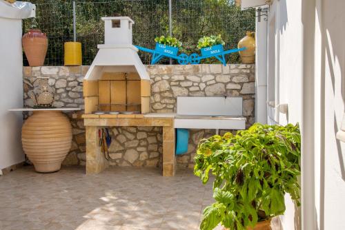 un patio con una mesa y una pared de piedra en Casa Soula, Gaios Seaview Cottage, en Gáios