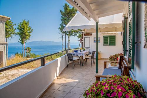balcón con mesa y sillas y vistas al océano en Casa Soula, Gaios Seaview Cottage, en Gáios