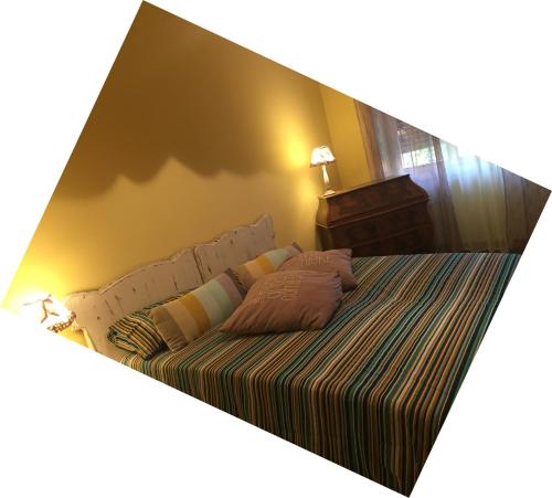 a bedroom with a large bed with a striped blanket at Appartamento San Siro in Milan