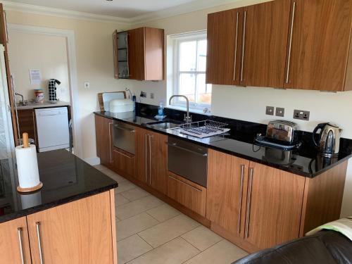 a kitchen with wooden cabinets and black counter tops at Rohallian in Stanley