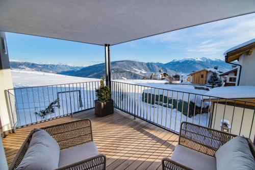 a balcony with two chairs and a view of mountains at ZI.INS Apartments in Maranza