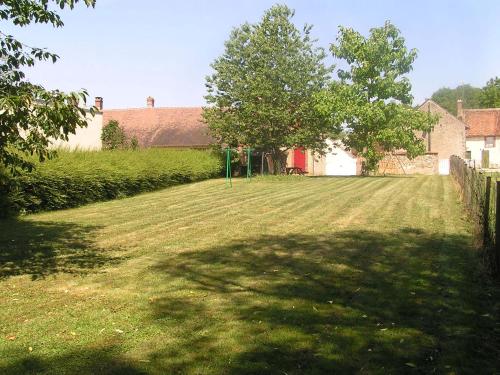 a large field of grass with a fence and trees at Gîte de Lavau in Lavau
