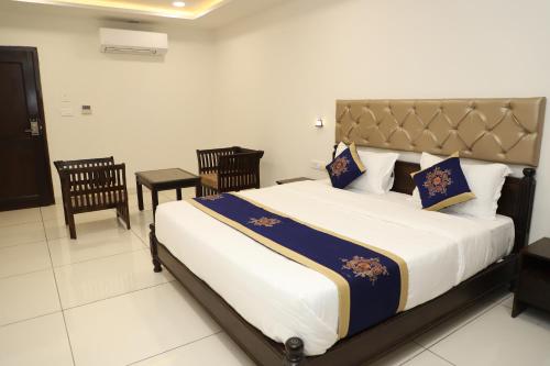 a bedroom with a large bed and two chairs at Clover Inn in Udaipur
