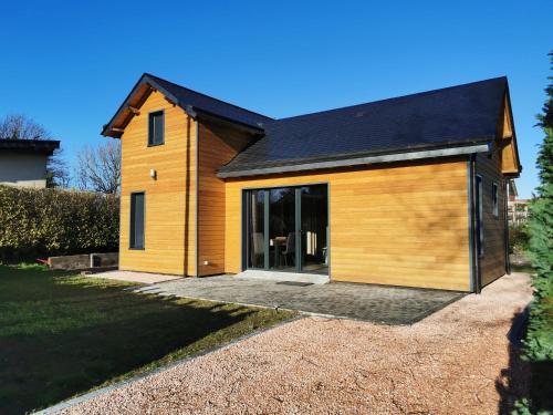 ein großes Holzhaus mit großer Garage in der Unterkunft Le Petit Renard in Saint-Jouin-Bruneval