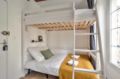 ein kleines Schlafzimmer mit einem Etagenbett und einer Leiter in der Unterkunft Cosy Mezzanine Studio in the Heart of Paris (4) in Paris