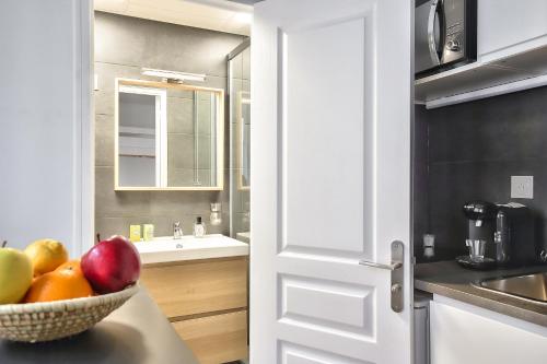 - un bol de fruits sur un comptoir dans la cuisine dans l'établissement Cosy Mezzanine Studio in the Heart of Paris (4), à Paris