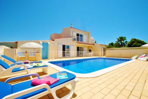 a villa with a swimming pool in front of a house at Villa Margarita in Carvoeiro