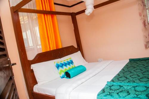 a bedroom with a bed with a wooden head board at The White Dove - in Milimani Kisumu in Kisumu