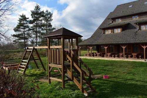 a wooden playground in front of a house at Motel Roubenka in Týniště nad Orlicí