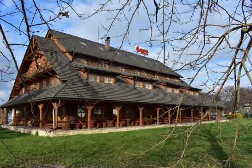 ein großes Holzgebäude mit schwarzem Dach in der Unterkunft Motel Roubenka in Týniště nad Orlicí