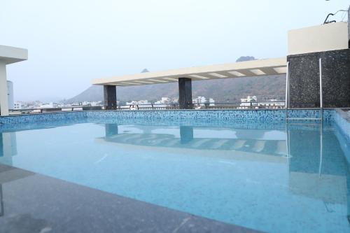 a large blue swimming pool on top of a building at Clover Inn in Udaipur