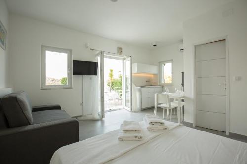 a white living room with a bed and a table at Vila Visnjic in Grebaštica