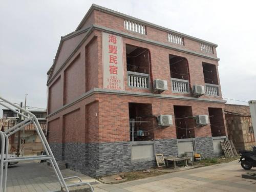 a red brick building with a building under construction at 海豐民宿 Haifeng Bed and Breakfast in Jincheng