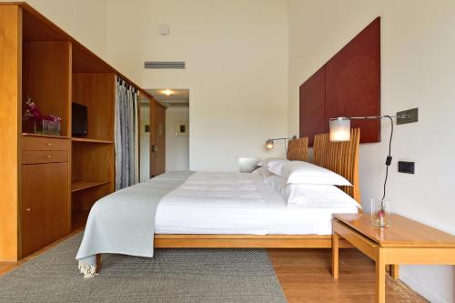 a bedroom with a large bed and a desk at Pousada Convento de Arraiolos in Arraiolos