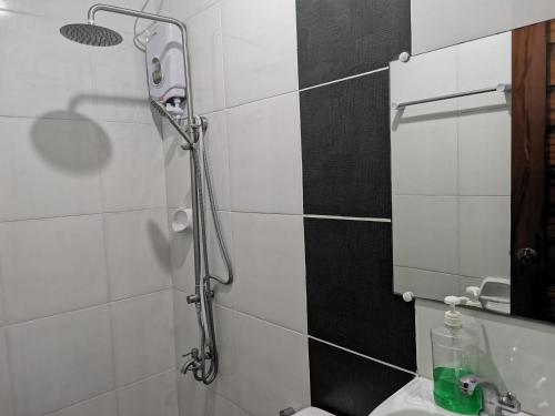 eine Dusche im Bad mit WC und Waschbecken in der Unterkunft RedDoorz Plus @ Jollydays Hotel Nueva Ecija in San Jose