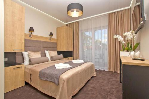 a bedroom with a bed with a desk and a window at Ośrodek Promenada- Horyzont in Jastrzębia Góra
