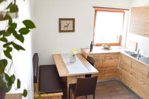 cocina con mesa de madera, sillas y fregadero en Niedermairhof, en Falzes