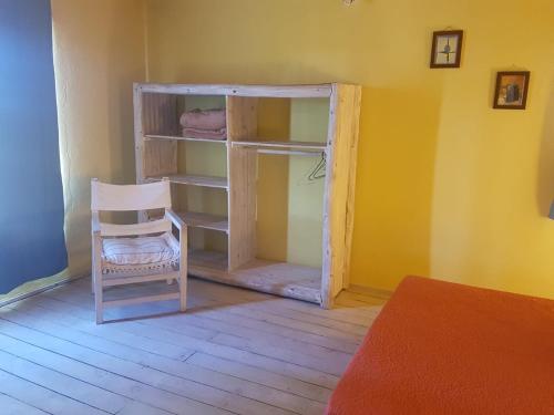 a room with a chair and a book shelf at Riyadh - en el bosque a metros de la playa in Rincón de los Oliveras