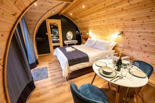 una camera con letto, tavolo e sedie di North Coast 500 Pods - Brora a Brora