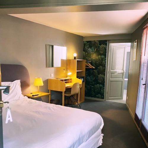 a bedroom with a bed and a desk and a table at Fab House - Les Maisons Fabuleuses in Senlis