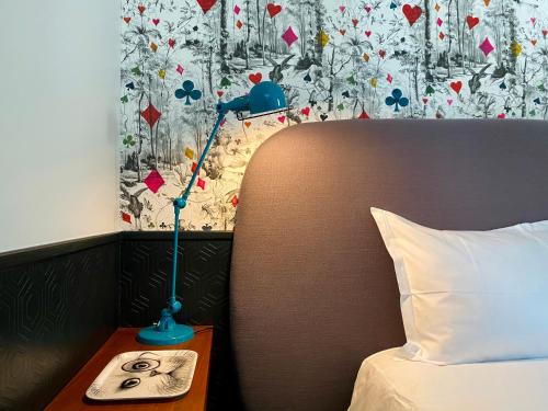 a lamp on a night stand next to a bed at Fab House - Les Maisons Fabuleuses in Senlis