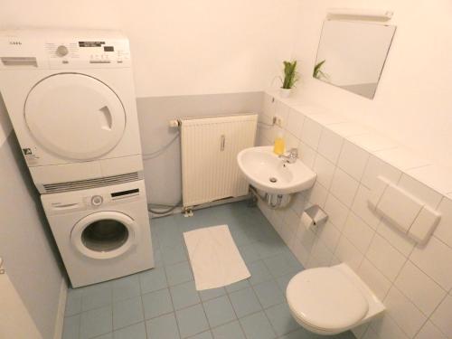 y baño con lavadora y lavamanos. en SUNNYHOME Monteurwohnungen und Apartments in Schwandorf, en Schwandorf