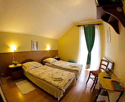 ジェールにあるMuskátli Panzióのベッド2台と窓が備わるホテルルームです。