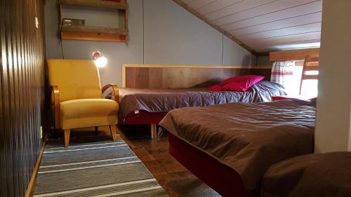 アカスロンポロにあるHostel Sivakkaのベッドルーム1室(ベッド2台、黄色い椅子付)