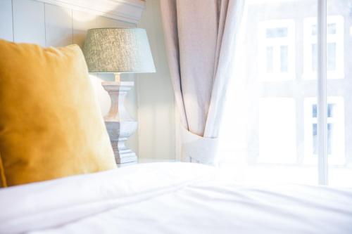 a bedroom with a bed with a lamp and a window at Logement Petit Beijers in Utrecht