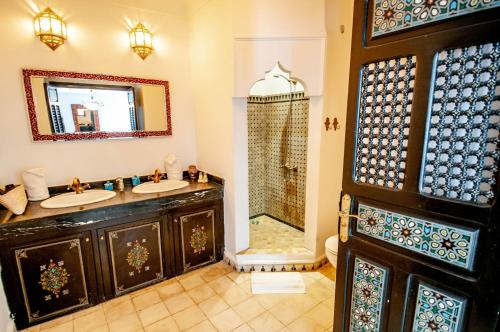 a bathroom with two sinks and a shower at Riad Makila in Marrakech