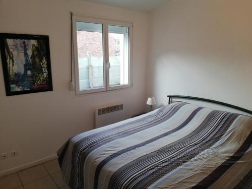 une chambre avec un lit et une fenêtre dans l'établissement logement entier au calme, à Villers-Outréaux